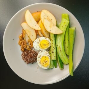 A nutritious and balanced breakfast bowl featuring eggs, fruits, and vegetables.